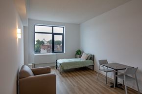 Bronx apartment for rent - A bedroom with a bed, chair, and table.