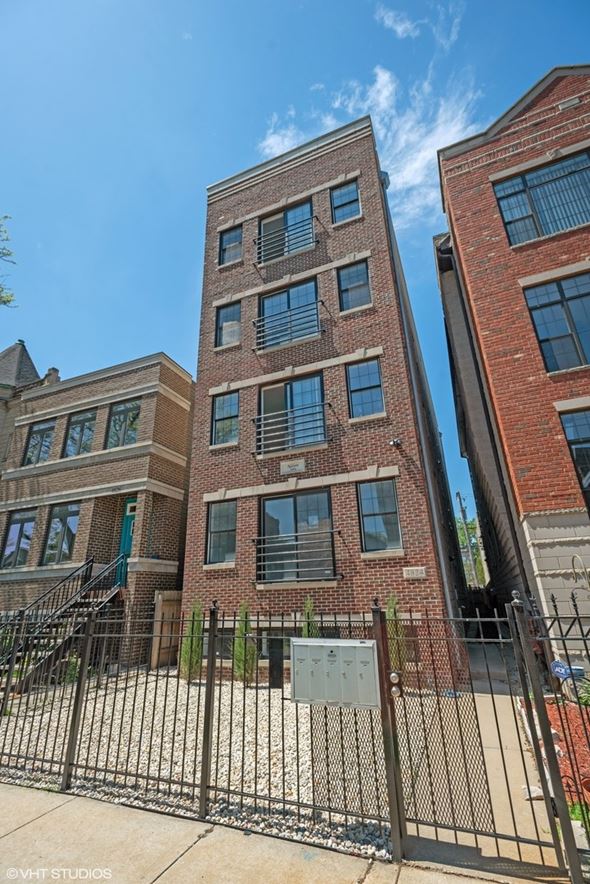 Chicago apartment for rent - a large brick building with a gate in front of it
