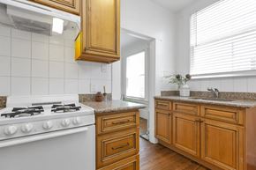 San Francisco apartment for rent - a kitchen with wooden cabinets and a white stove
