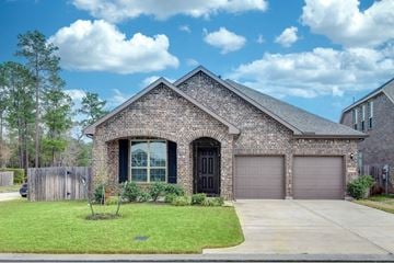 Spring apartment for rent - a brick house with a driveway and a garage door