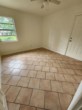 Pensacola house for rent - an empty living room with a tiled floor and a window