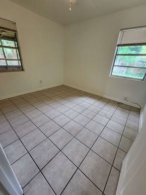 Pensacola house for rent - an empty room with a tiled floor and two windows