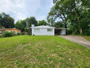 Pensacola house for rent - a small white house with a yard in front of it