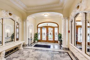 San Francisco apartment for rent - A hallway with a marble floor and a large wooden door.