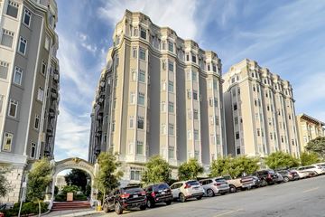 San Francisco apartment for rent - A row of parked cars in front of a large building with a gate.