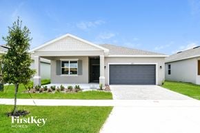 Kissimmee house for rent - A white house with a garage door is for sale by FirstKey Homes.