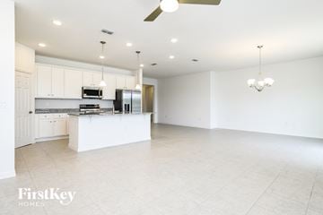 Kissimmee house for rent - A spacious kitchen with white cabinets and a large island.