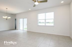 Kissimmee house for rent - A spacious room with a ceiling fan and a large window.