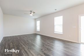 Greenville house for rent - A spacious room with wooden flooring and a ceiling fan.