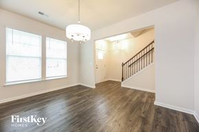 Greenville house for rent - A spacious room with wooden floors and a staircase.