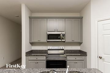Bartow house for rent - A kitchen with a stove top oven and microwave above it.