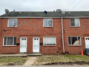 Clairton house for rent - A red brick house with white doors and windows.
