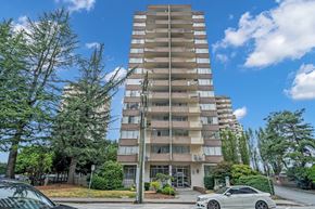 New Westminster apartment for rent - A tall residential building with a parking lot in front.