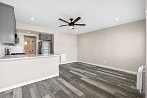 Brea apartment for rent - an empty living room with a kitchen and a ceiling fan