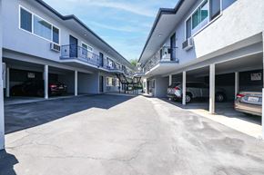 Brea apartment for rent - a parking lot with cars parked in front of a building