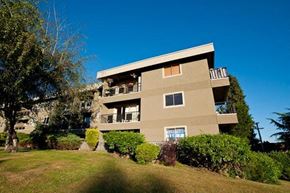 New Westminster apartment for rent - A beige building with a balcony on the second floor.