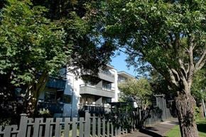 Victoria apartment for rent - A white building with a fence in front of it.