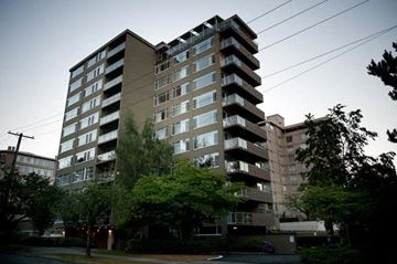 Vancouver apartment for rent - A tall residential building with balconies on the upper floors.