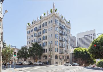 San Francisco apartment for rent - A large building with many windows and balconies is in the middle of a city street.