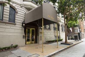 San Francisco apartment for rent - The entrance to a building with a brown awning and gold door.