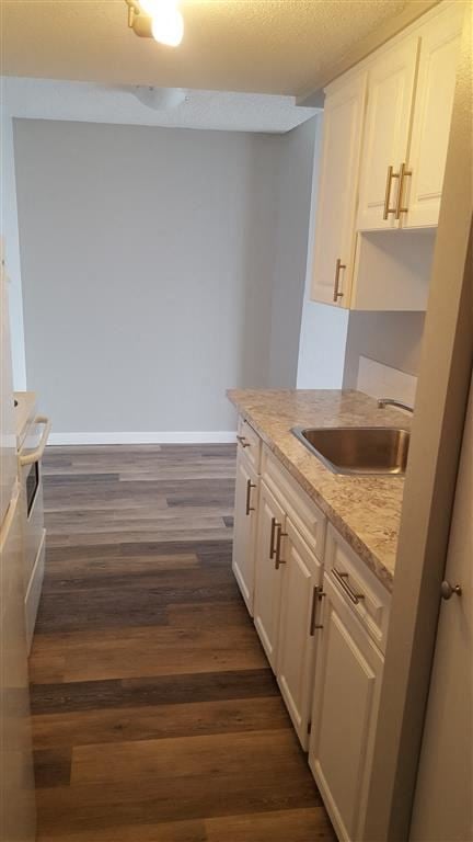 New Westminster apartment for rent - A kitchen with wooden floors and white cabinets.