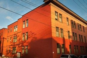 Vancouver apartment for rent - A red brick building with a parking lot in front.