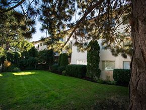 Victoria apartment for rent - A house with a green lawn and trees in front.
