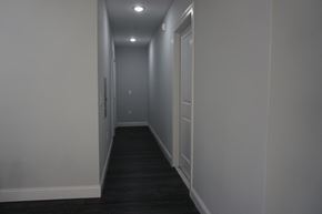 Paterson apartment for rent - a hallway with white walls and a black carpet and white doors