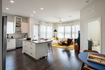 Cocoa apartment for rent - A modern kitchen with white cabinets and a wooden floor.
