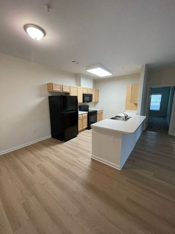 Aiken apartment for rent - A kitchen with black appliances and wooden floors.