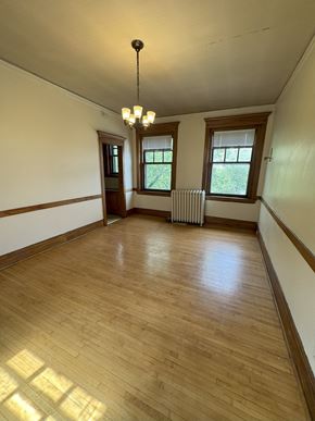 Duluth apartment for rent - A room with wooden floors and a chandelier.