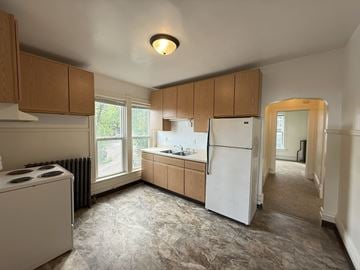 Duluth apartment for rent - A kitchen with a white refrigerator and wooden cabinets.