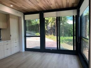 Vancouver apartment for rent - A modern interior with a view of a tree-lined road through the glass doors.