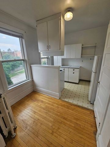 Duluth apartment for rent - A kitchen with white cabinets and a wooden floor.