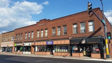 Duluth apartment for rent - A street view of a brick building with various storefronts.