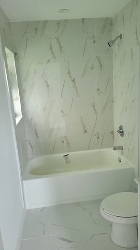 Miami apartment for rent - a white bathroom with a tub and a toilet