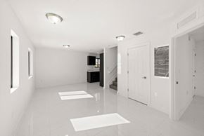 Miami apartment for rent - a large white room with white tiles and a white door