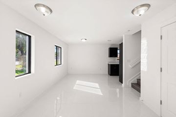 Miami apartment for rent - an empty living room with white walls and white tile floors