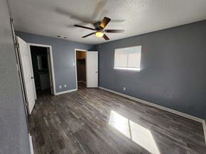 Killeen apartment for rent - A room with a ceiling fan and wooden flooring.