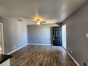 Killeen apartment for rent - A room with a ceiling fan and wooden flooring.
