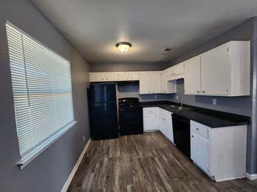 Killeen apartment for rent - A kitchen with black countertops and white cabinets.