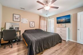 Hubert house for rent - a bedroom with a bed and a ceiling fan