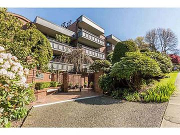Vancouver apartment for rent - A residential building with a driveway and flowering bushes.