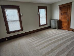 Warren apartment for rent - a large empty room with a wooden door and two windows