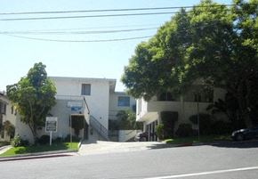West Hollywood apartment for rent - a white apartment building with trees in front of it