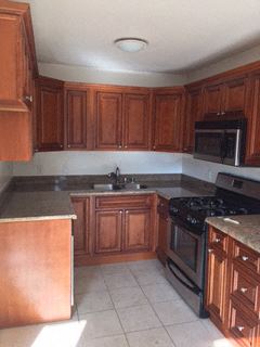 Los Angeles apartment for rent - an empty kitchen with wooden cabinets and black appliances