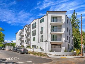 Studio City apartment for rent - a white apartment building with cars parked in front of it
