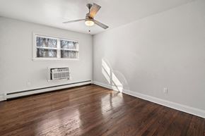 Neptune apartment for rent - an empty living room with wood floors and a ceiling fan
