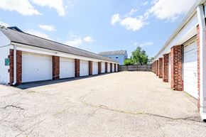 Clifton apartment for rent - a long row of garages with white doors and brick columns