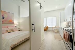 Nashville apartment for rent - A bedroom with a bed and a kitchen area in the same room.
